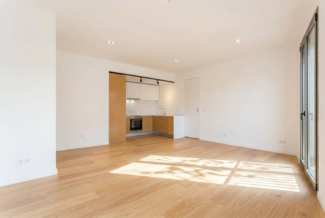 Sala depois — paredes brancas, pavimento em carvalho claro e cozinha em U integrada ao fundo — Barceloneta, Barcelona
