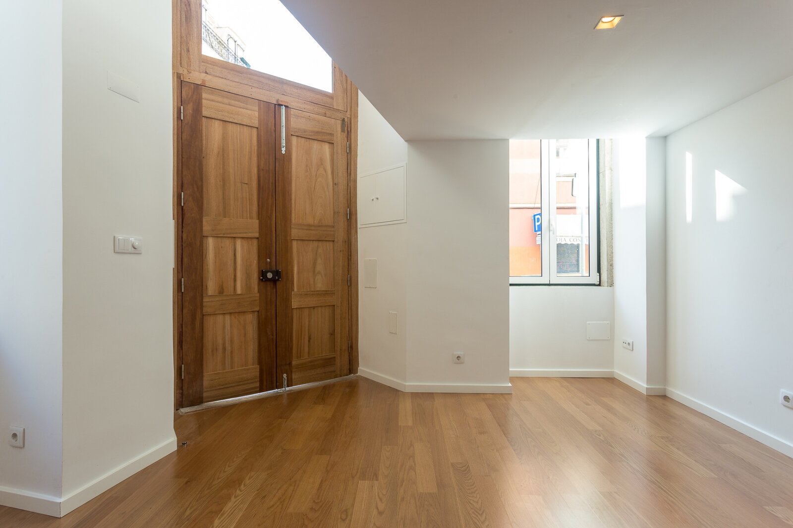 Porta de entrada original em madeira maciça preservada — loft no Bairro das Colónias, Lisboa