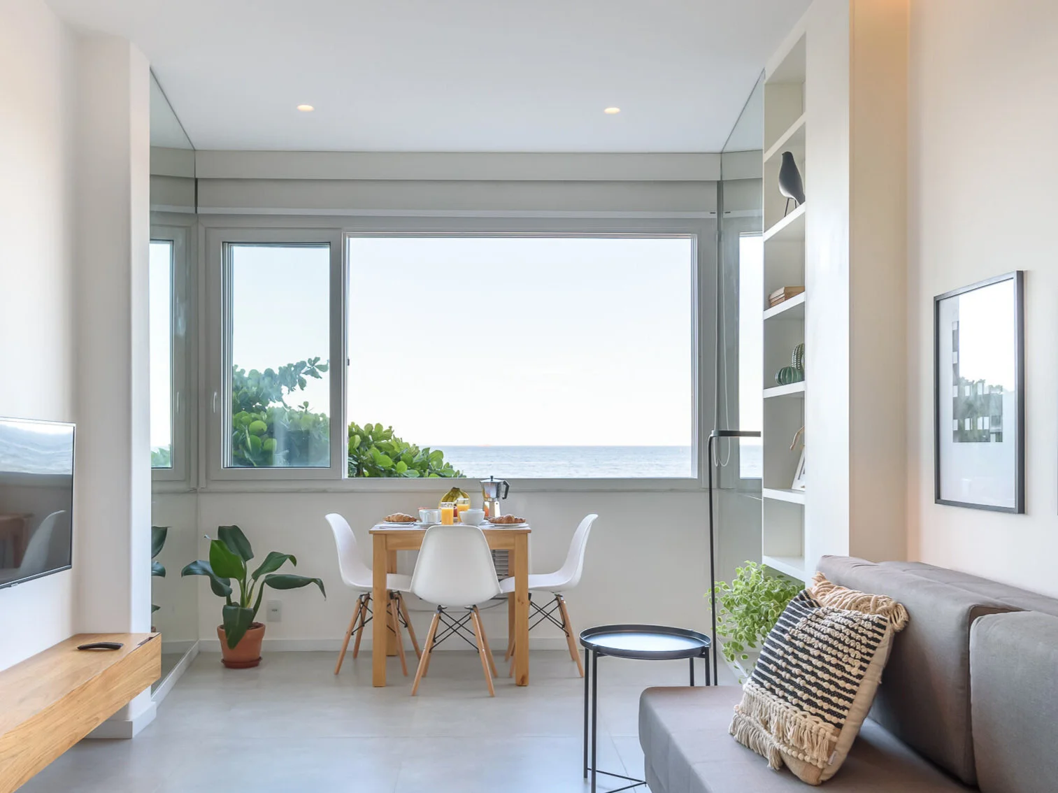 Sala depois — pavimento em madeira clara, têxteis naturais e luz do mar de Copacabana — Rio de Janeiro