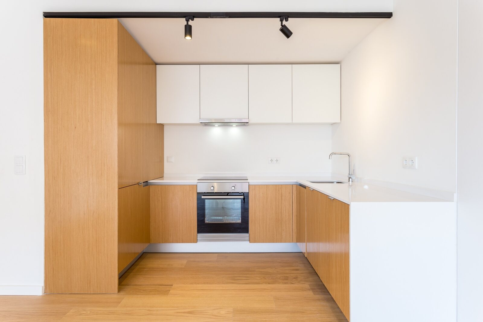 Apartamento remodelado de 75m² na Barceloneta, Barcelona — sala com pavimento em carvalho e cozinha integrada em U, projecto Palavra Decimal