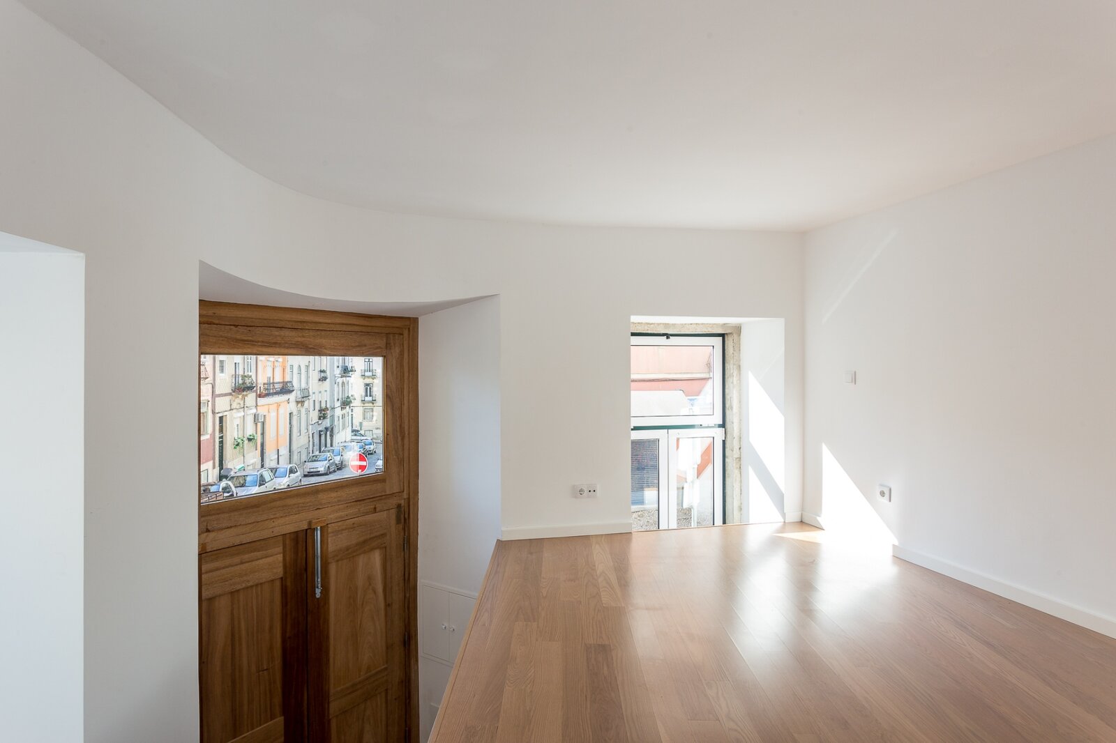 Quarto no piso superior com janela original e vista para o bairro — loft Bairro das Colónias, Lisboa