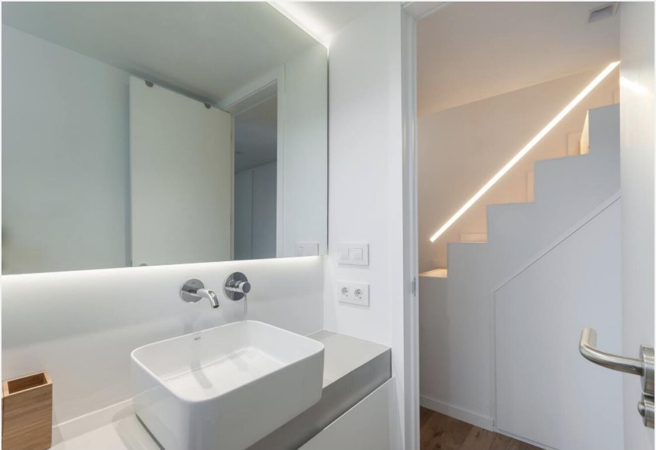 Casa de banho com lavatório, espelho e vista para a escada do mezanino — Madrid