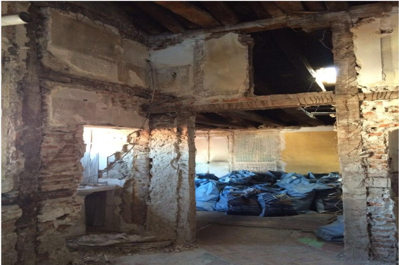 Estado original das paredes em pedra e tijolo antes da remodelação — apartamento em Madrid