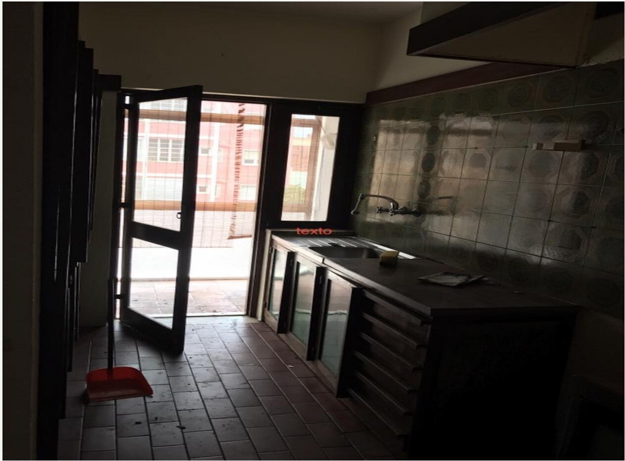 Cozinha antes da remodelação — azulejos verdes padronizados, móveis baixos antigos em vidro e pavimento em ladrilho — Barceloneta