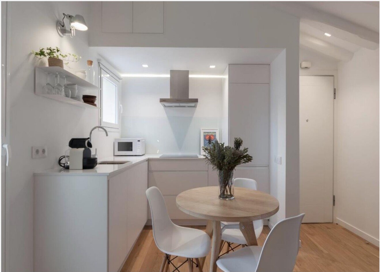 Cozinha minimalista com mesa redonda em carvalho e cadeiras Eames brancas, Madrid
