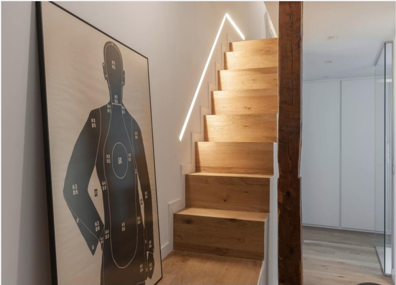 Escada para mezanino em madeira com peça gráfica de silhueta humana em grande formato, Madrid