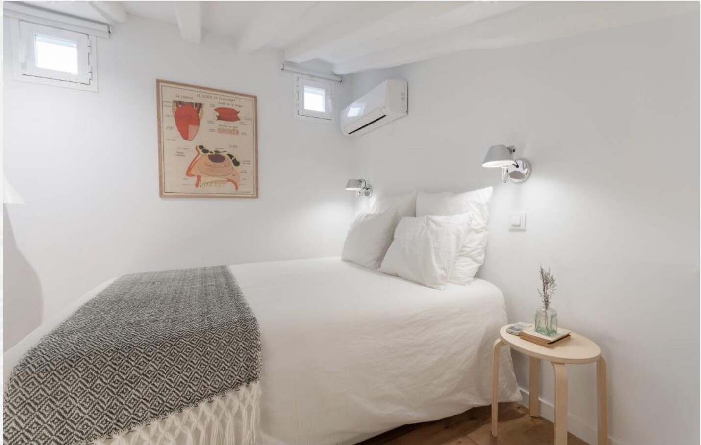 Quarto com cama de casal, candeeiros de leitura na parede e mesa de cabeceira em madeira — Madrid