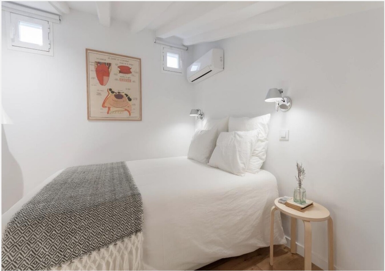 Quarto com cama de casal, candeeiros de leitura na parede e poster anatómico emoldurado, Madrid