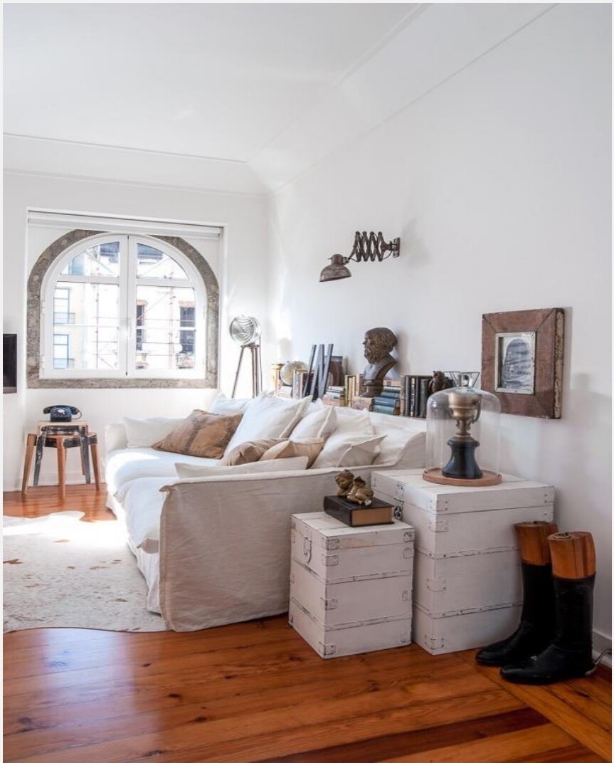 Sala com sofá branco junto à janela em arco e pavimento em pinho original, Avenida da Liberdade