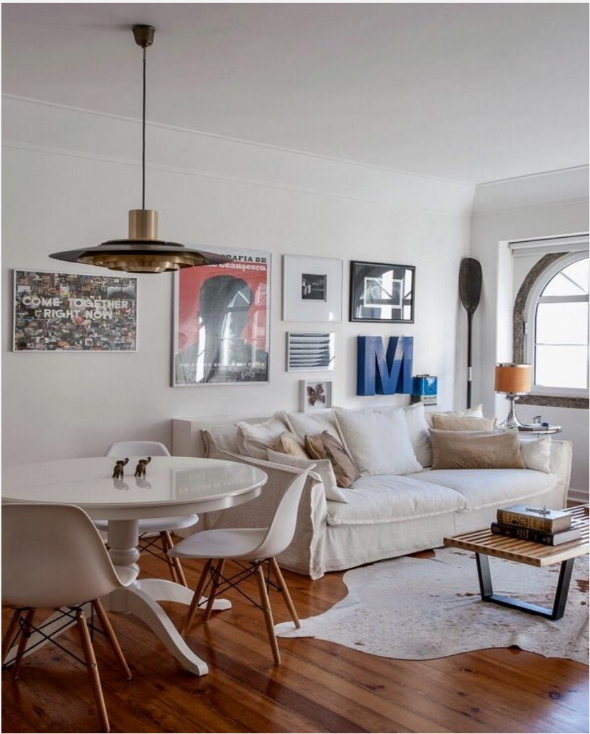 Sala-jantar com sofá branco, mesa de jantar e arte de parede, Avenida da Liberdade
