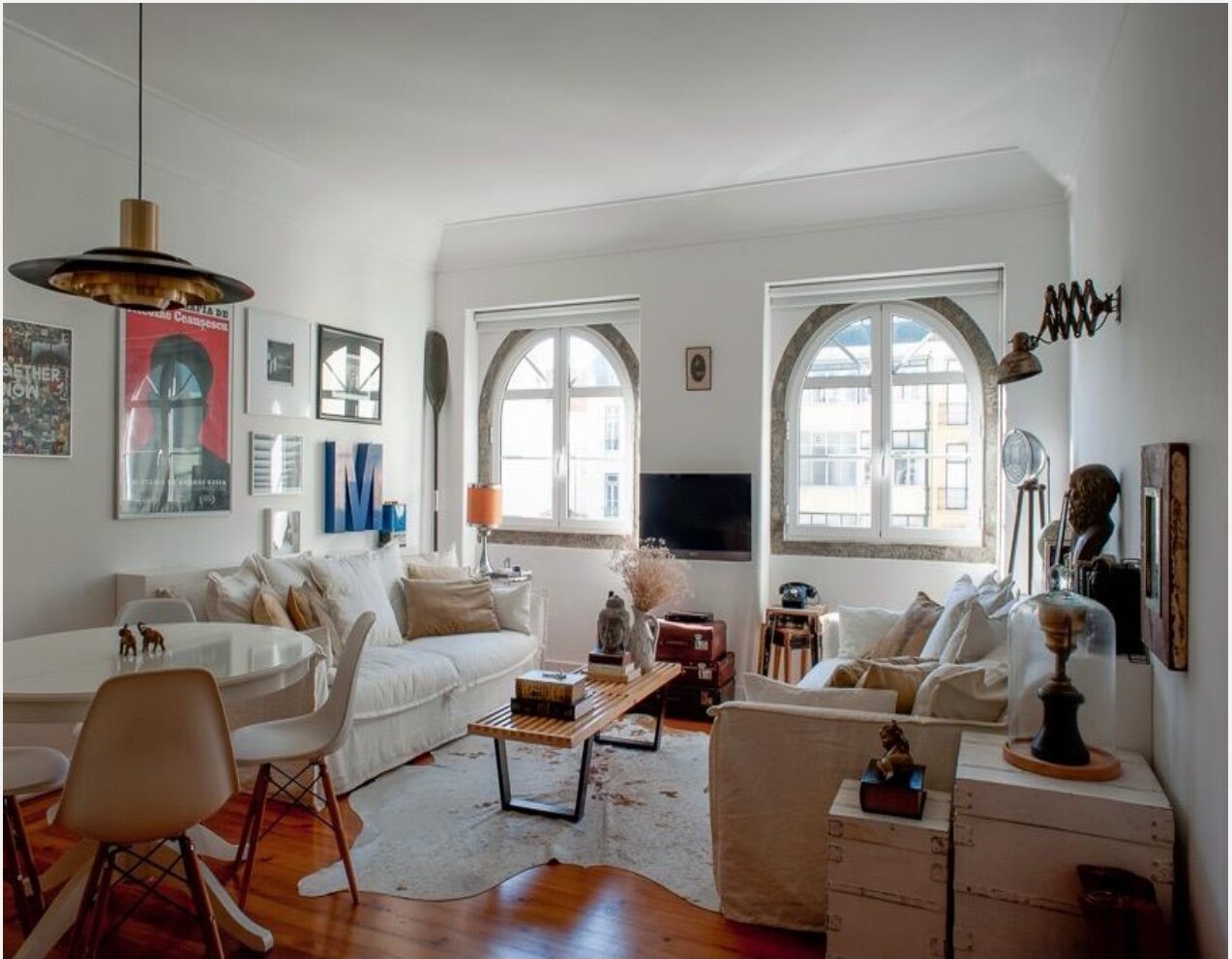 Sala decorada de apartamento na Avenida da Liberdade, Lisboa — sofás brancos, janelas em arco e mistura de peças vintage e contemporâneas · Palavra Decimal
